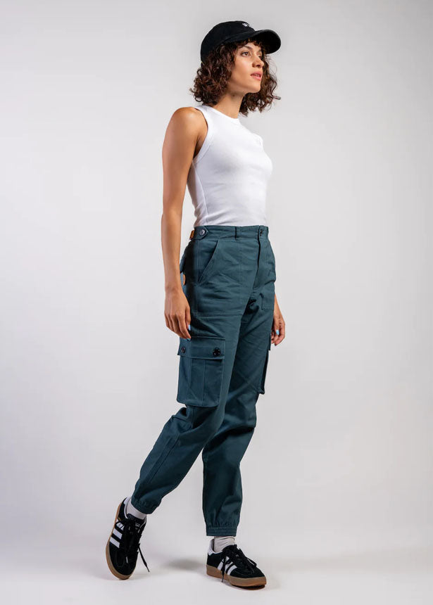 Wondery Brand Isabel OUtdoor pant in teal showing side view with cargo pockets, belt and highwaist